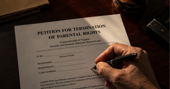 Hands holding a pen while reviewing a petition for the termination of parental rights.